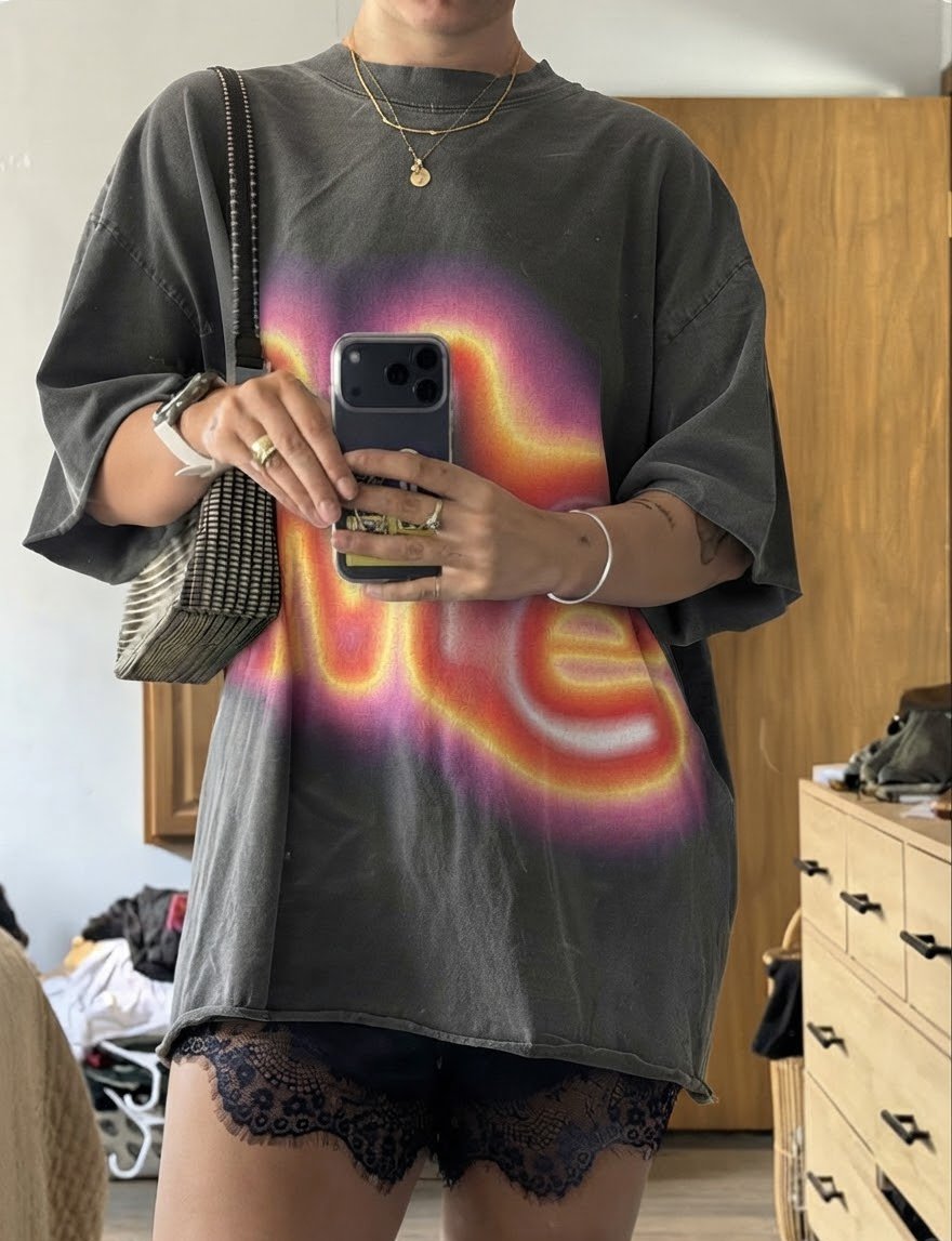 Mirror selfie in a faded charcoal oversized T-shirt with a large glowing living-letter print