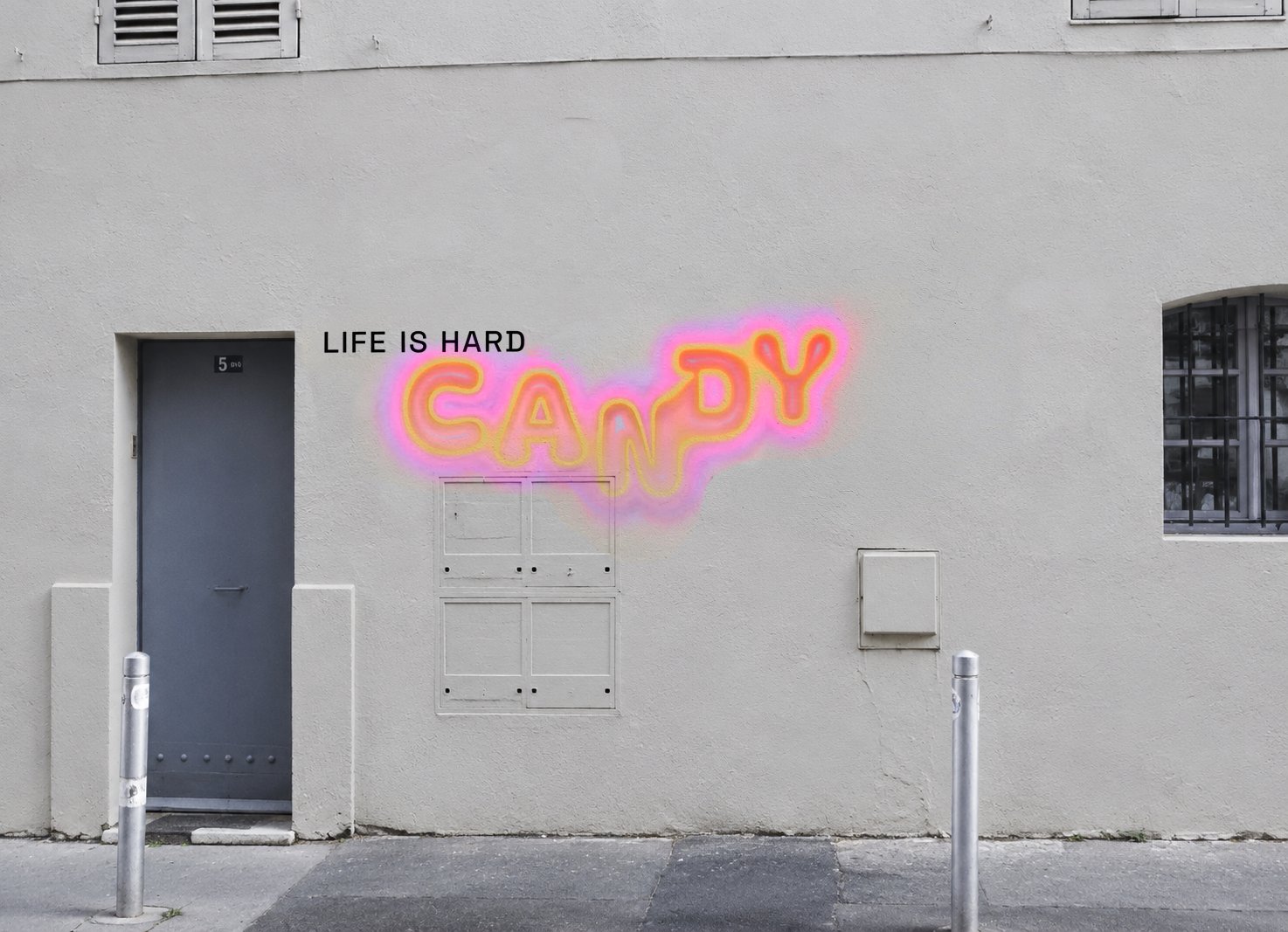 A light city wall with the words LIFE IS HARD and CANDY in large glowing living letters